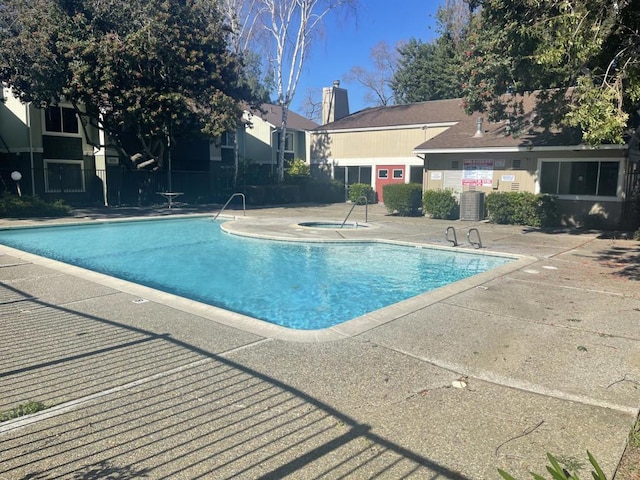 view of swimming pool featuring a patio area and central air condition unit