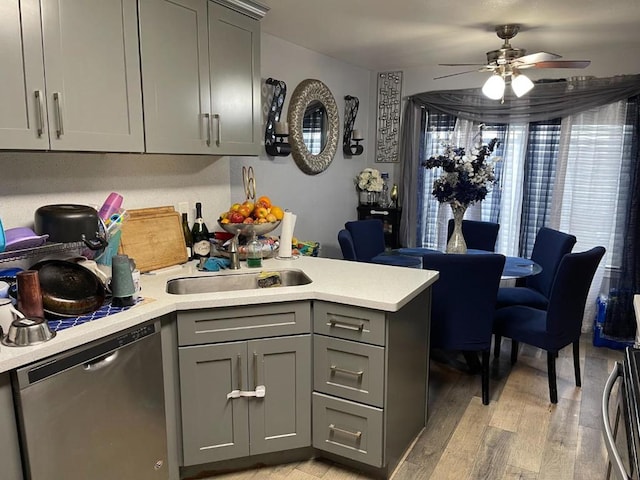 kitchen with gray cabinets, dishwasher, sink, ceiling fan, and light wood-type flooring