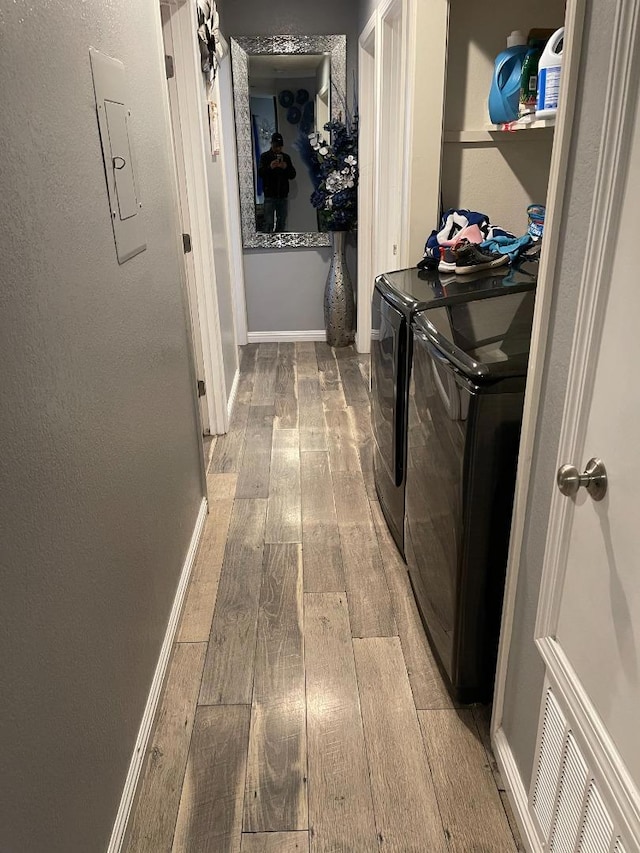 washroom featuring hardwood / wood-style flooring and washing machine and dryer