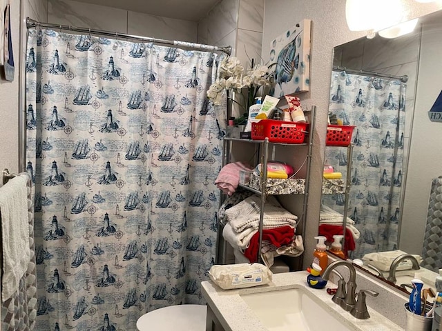 bathroom featuring walk in shower, vanity, and toilet