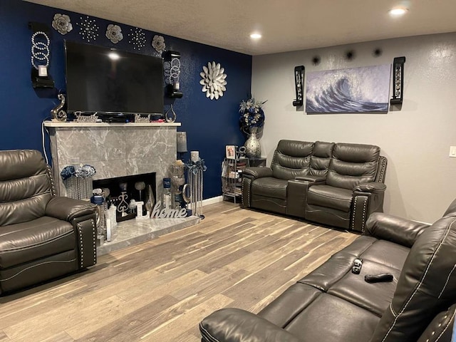 living room featuring a tiled fireplace and hardwood / wood-style floors