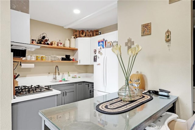 kitchen with white refrigerator, sink, white cabinets, and gray cabinets