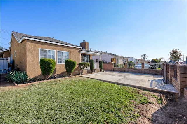 rear view of property featuring a patio area and a lawn