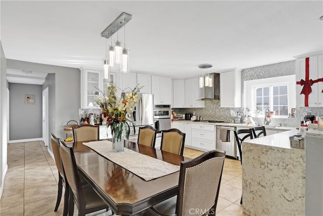 dining room with sink, a chandelier, and light tile patterned flooring