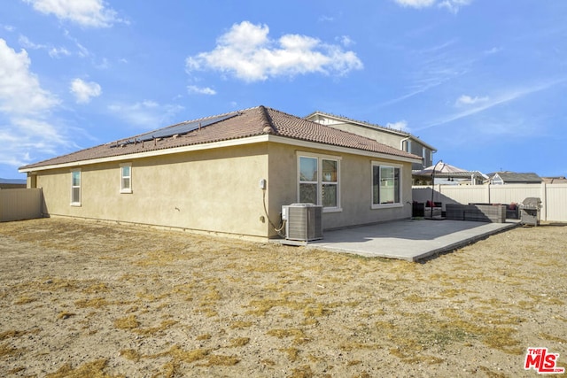 back of house with central AC, solar panels, and a patio