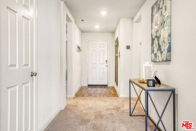 hallway with light colored carpet