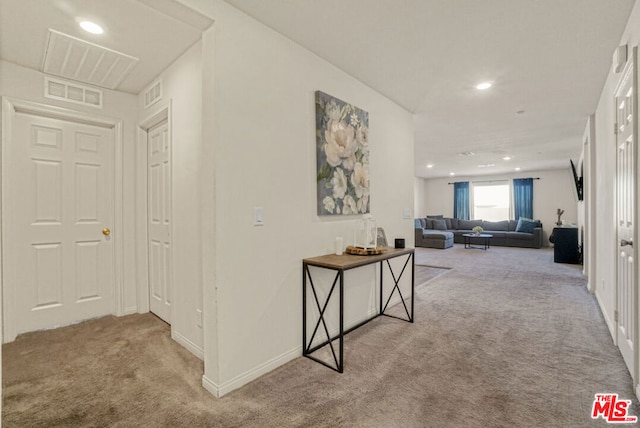 hallway featuring light colored carpet