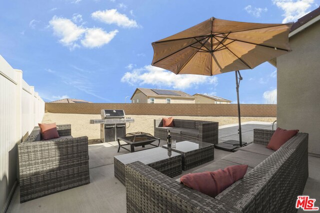 view of patio / terrace with grilling area and an outdoor living space with a fire pit