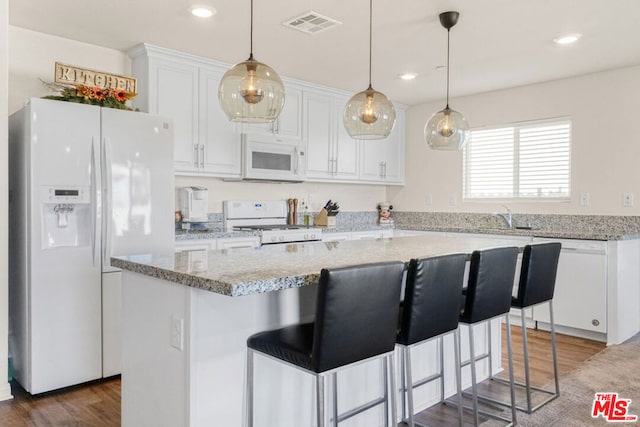 kitchen featuring dark hardwood / wood-style floors, a center island, white appliances, white cabinetry, and light stone countertops