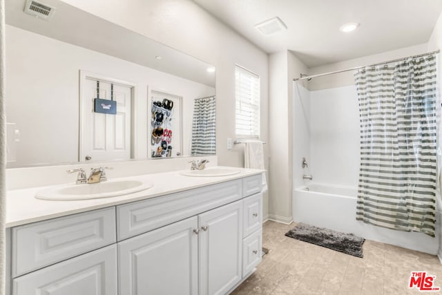 bathroom featuring vanity and shower / bathtub combination with curtain