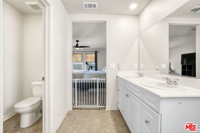 bathroom featuring ceiling fan, hardwood / wood-style floors, toilet, and vanity