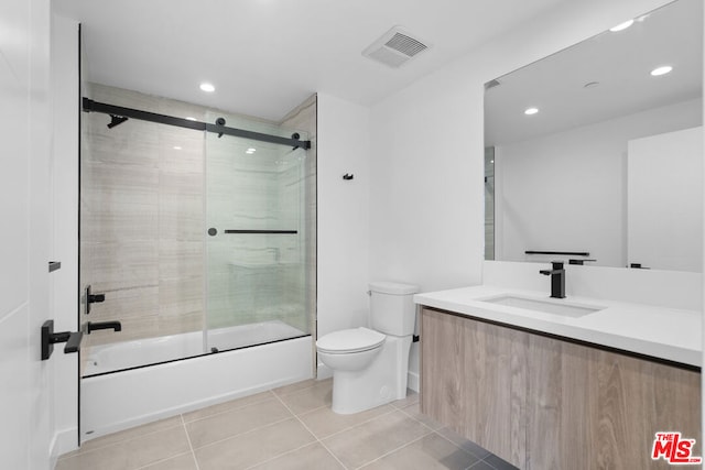 full bathroom featuring enclosed tub / shower combo, vanity, toilet, and tile patterned flooring