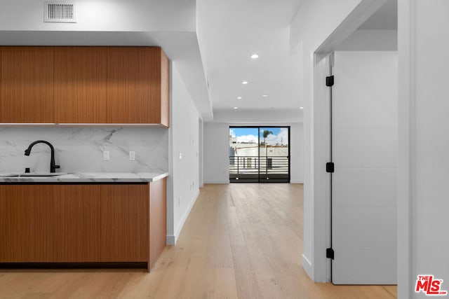 kitchen featuring decorative backsplash, sink, and light hardwood / wood-style floors