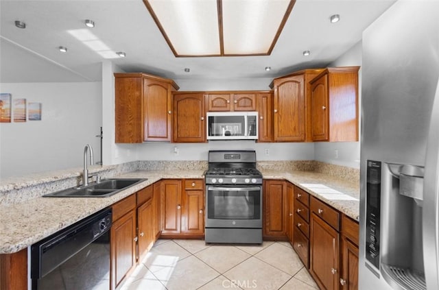 kitchen featuring light stone counters, sink, light tile patterned floors, and stainless steel appliances