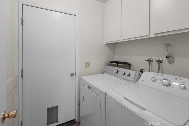 clothes washing area with washer and dryer and cabinets