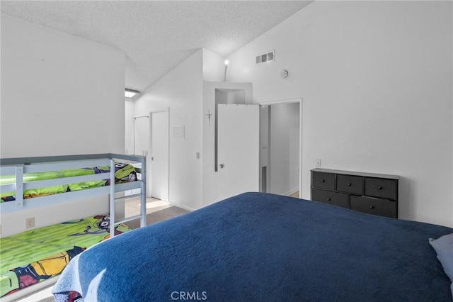 bedroom featuring a textured ceiling and vaulted ceiling