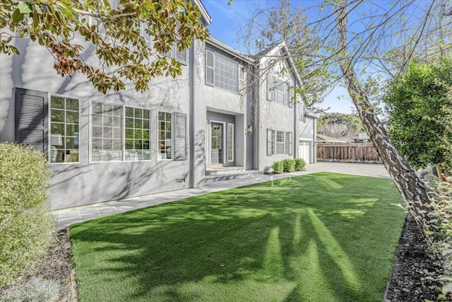 back of property with a patio area and a yard