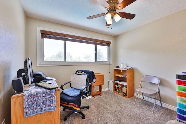 carpeted office space featuring ceiling fan