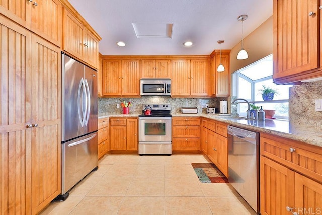 kitchen featuring decorative light fixtures, tasteful backsplash, sink, stainless steel appliances, and light tile patterned floors