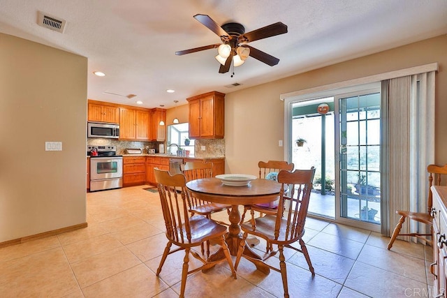 tiled dining space with ceiling fan