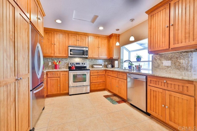 kitchen featuring decorative light fixtures, sink, light tile patterned flooring, light stone countertops, and stainless steel appliances