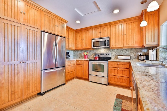 kitchen featuring sink, hanging light fixtures, light tile patterned floors, and stainless steel appliances