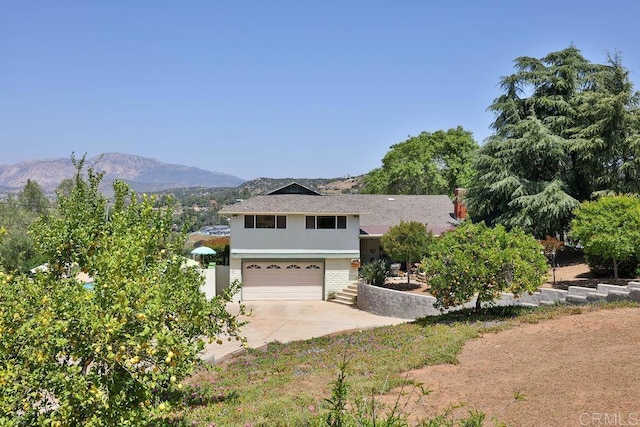 view of front of home with a garage and a mountain view