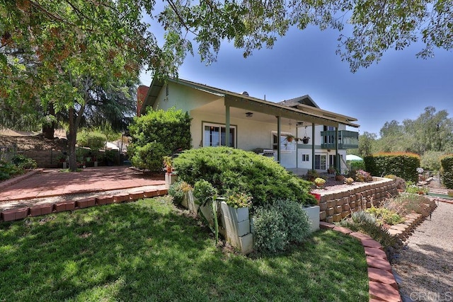 back of property with a balcony and a lawn