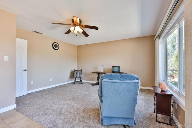 living area featuring light carpet and ceiling fan