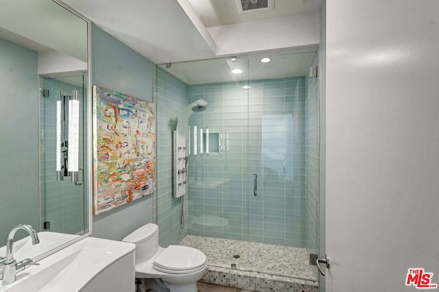 bathroom featuring walk in shower, vanity, and toilet