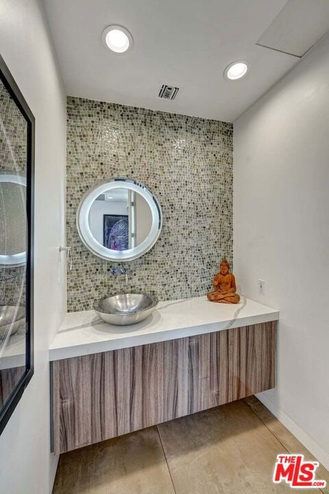 bathroom featuring backsplash, tile patterned floors, and vanity