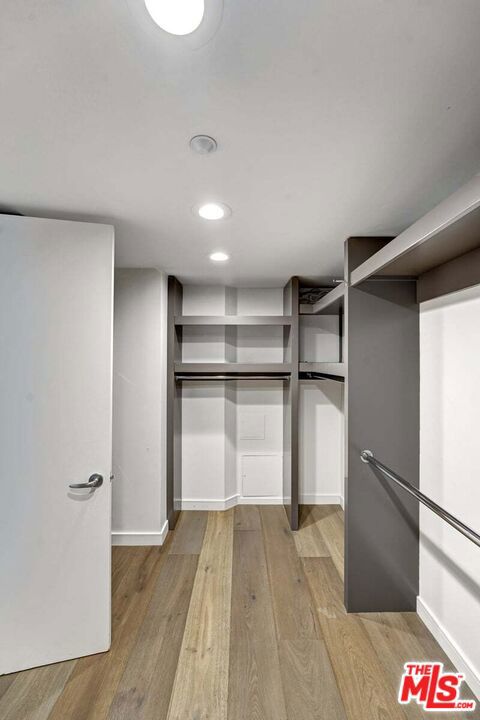 walk in closet with light wood-type flooring