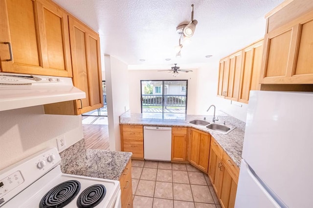 kitchen featuring sink, light stone counters, extractor fan, white appliances, and light tile patterned floors