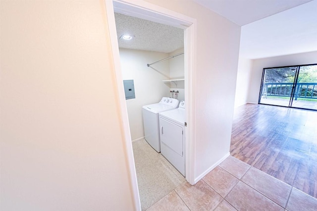 2374 Caringa Unit B, Carlsbad, CA 92009 - laundry area with light tile patterned floors, a textured ceiling, electric panel, and washing machine and clothes dryer