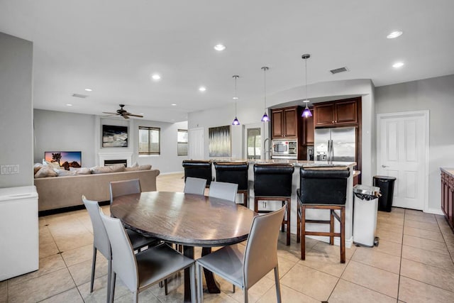 tiled dining space with ceiling fan