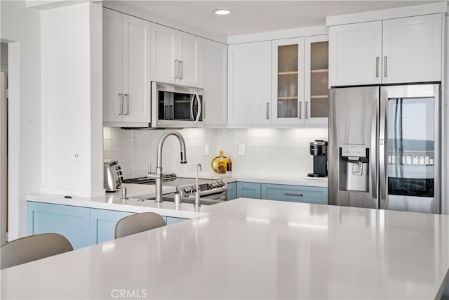 kitchen featuring decorative backsplash, white cabinetry, and stainless steel appliances