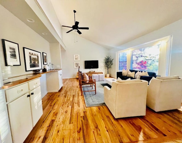 living room with ceiling fan, high vaulted ceiling, and light hardwood / wood-style floors