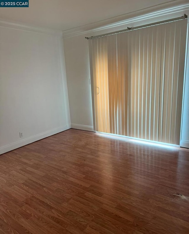 spare room with ornamental molding and wood-type flooring