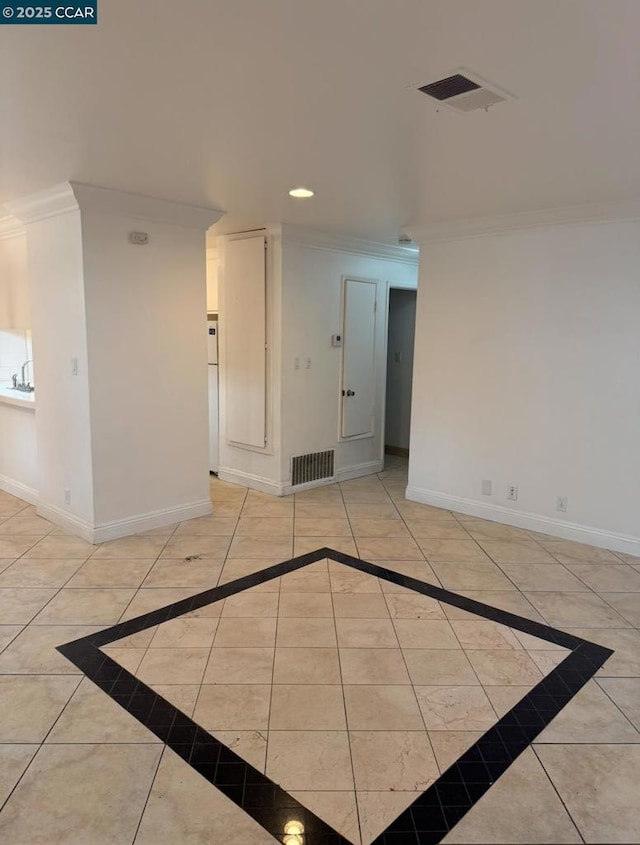 spare room featuring ornamental molding and light tile patterned flooring