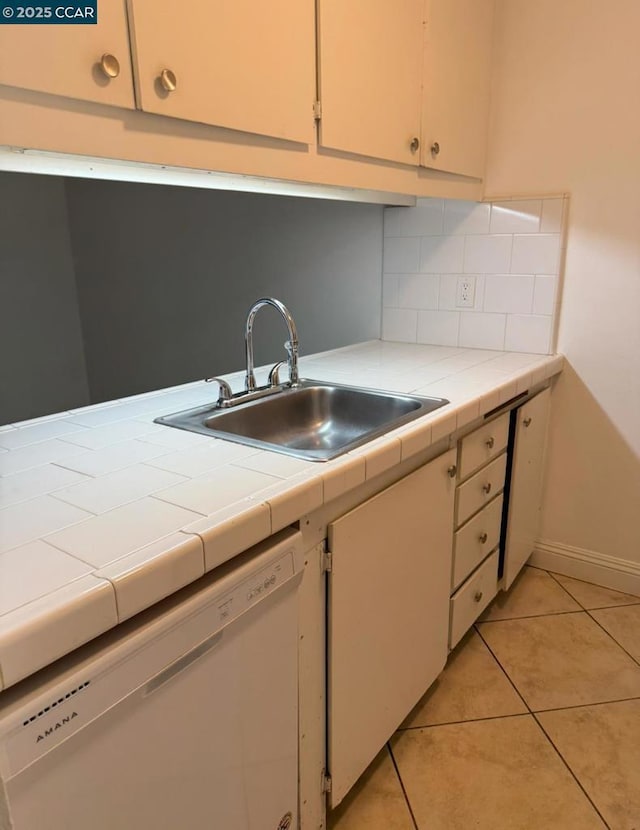 kitchen featuring sink, dishwasher, tile countertops, and light tile patterned flooring