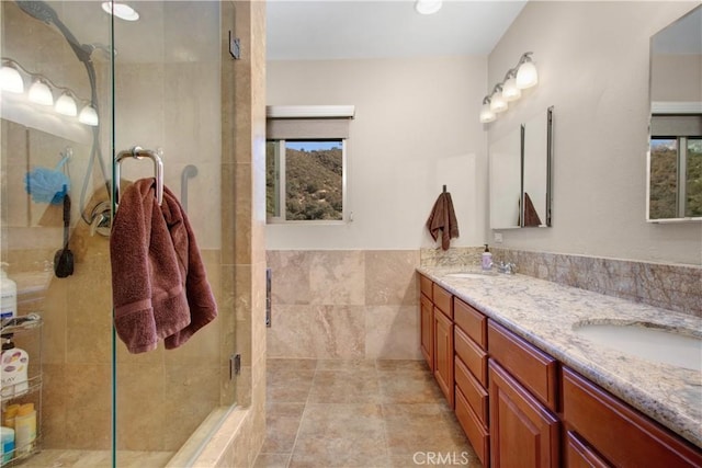 bathroom with vanity, tile walls, and an enclosed shower