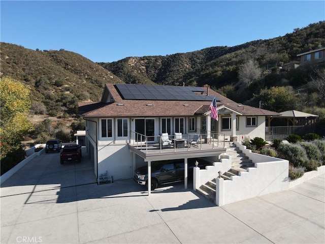 view of front of house featuring a mountain view and solar panels