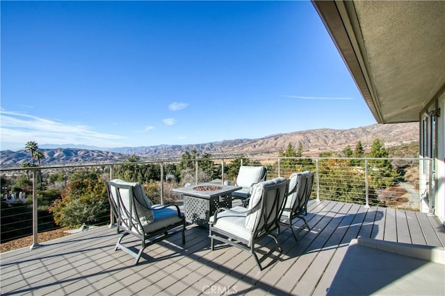 deck with a mountain view and an outdoor fire pit