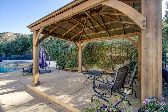 view of patio with a gazebo, a mountain view, and a fenced in pool