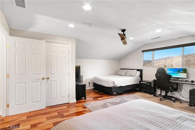 bedroom featuring ceiling fan, lofted ceiling, light hardwood / wood-style floors, and a closet