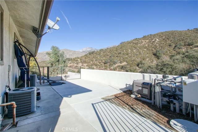 view of patio with central AC unit and a mountain view