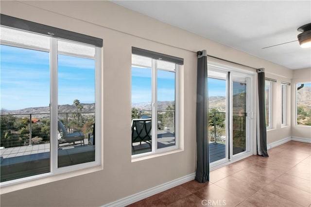 entryway with ceiling fan, a mountain view, and a healthy amount of sunlight