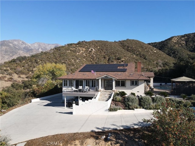 view of front of home featuring a mountain view and solar panels