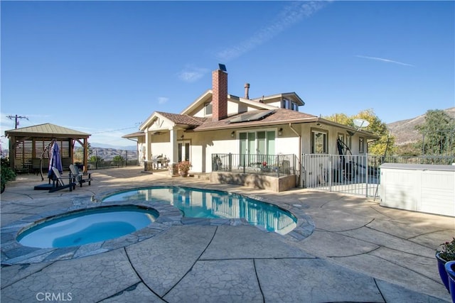 view of pool featuring a patio area, a mountain view, a gazebo, and an in ground hot tub