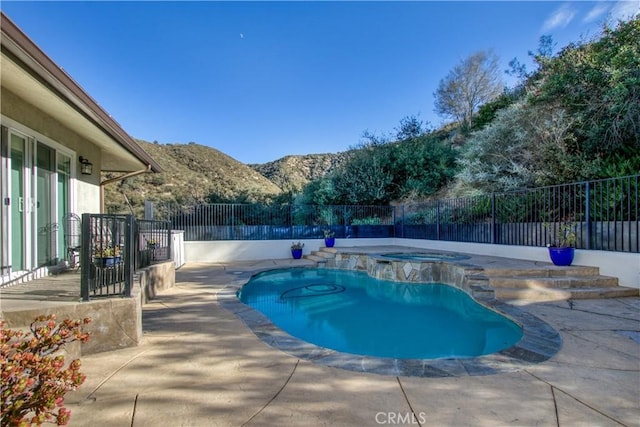 view of pool featuring a mountain view, an in ground hot tub, and a patio